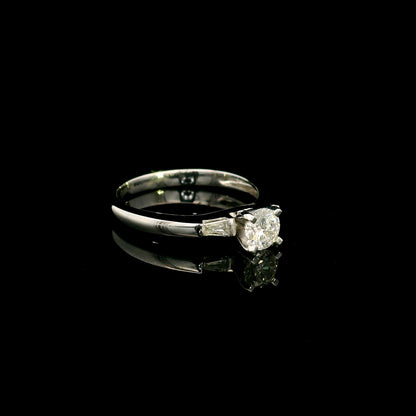 18K white gold round diamond solitaire ring with tapered baguette side diamonds and a classic elegant design.