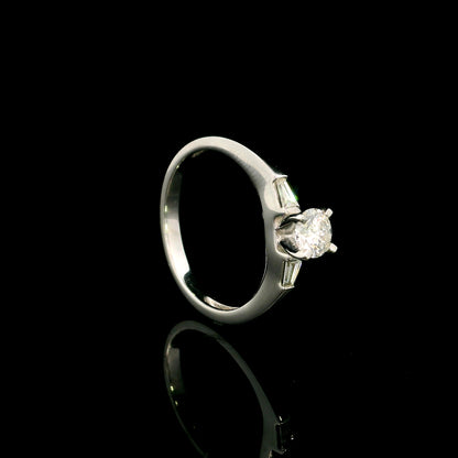 18K white gold round diamond solitaire ring with tapered baguette side diamonds and a classic elegant design.