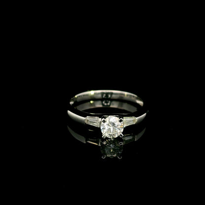 18K white gold round diamond solitaire ring with tapered baguette side diamonds and a classic elegant design.