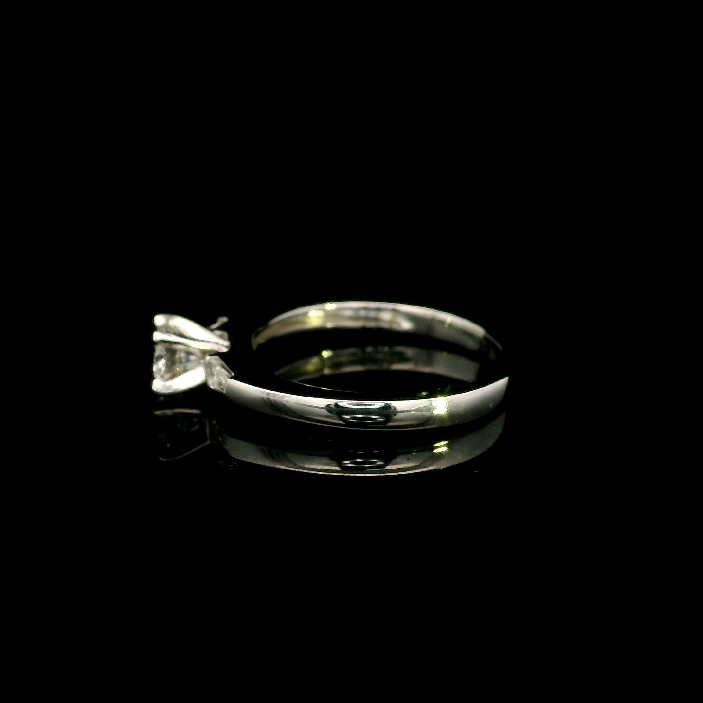 18K white gold round diamond solitaire ring with tapered baguette side diamonds and a classic elegant design.