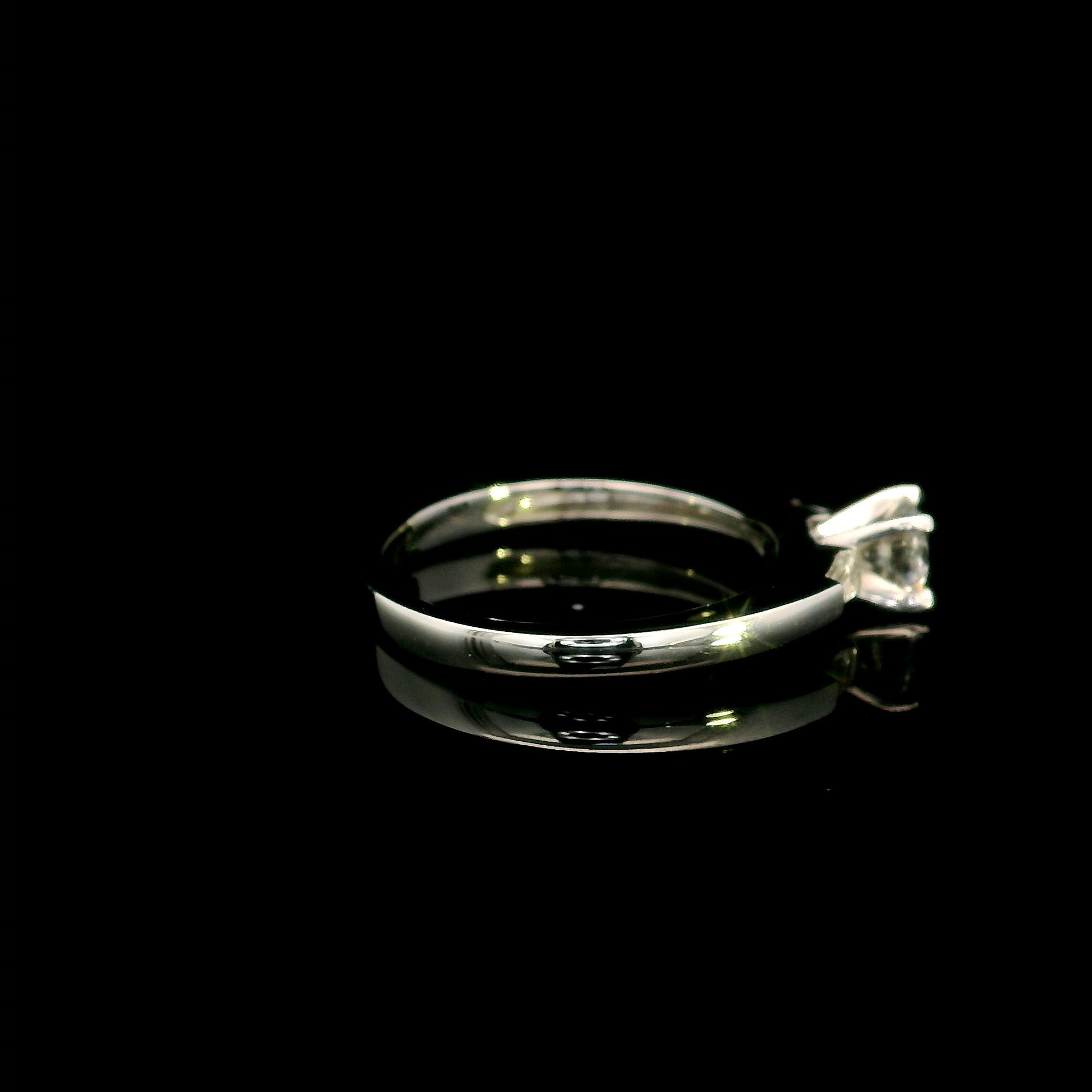 18K white gold round diamond solitaire ring with tapered baguette side diamonds and a classic elegant design.