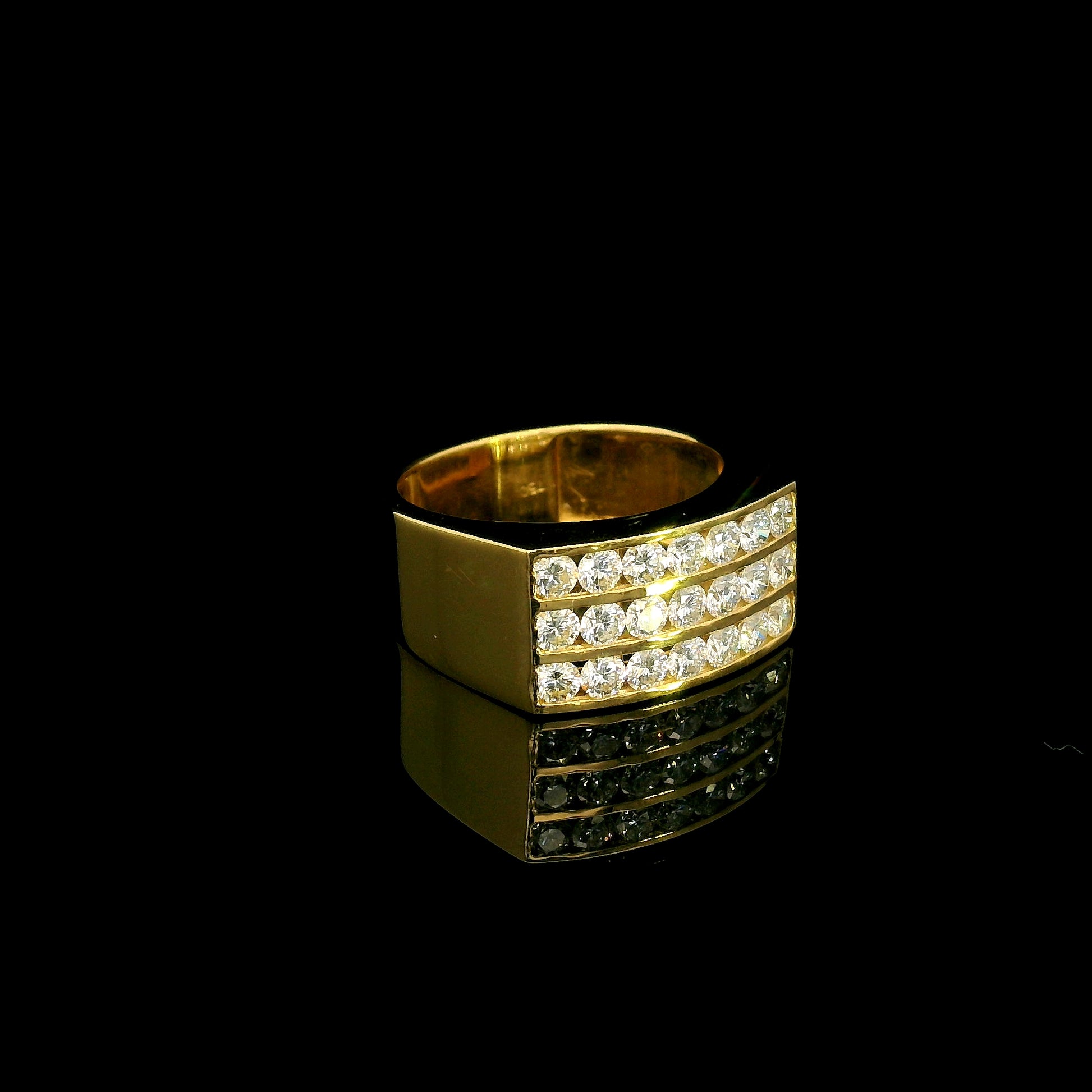 Men’s diamond statement ring in 18K yellow gold featuring three rows of round brilliant diamonds across a wide tapered gold band.