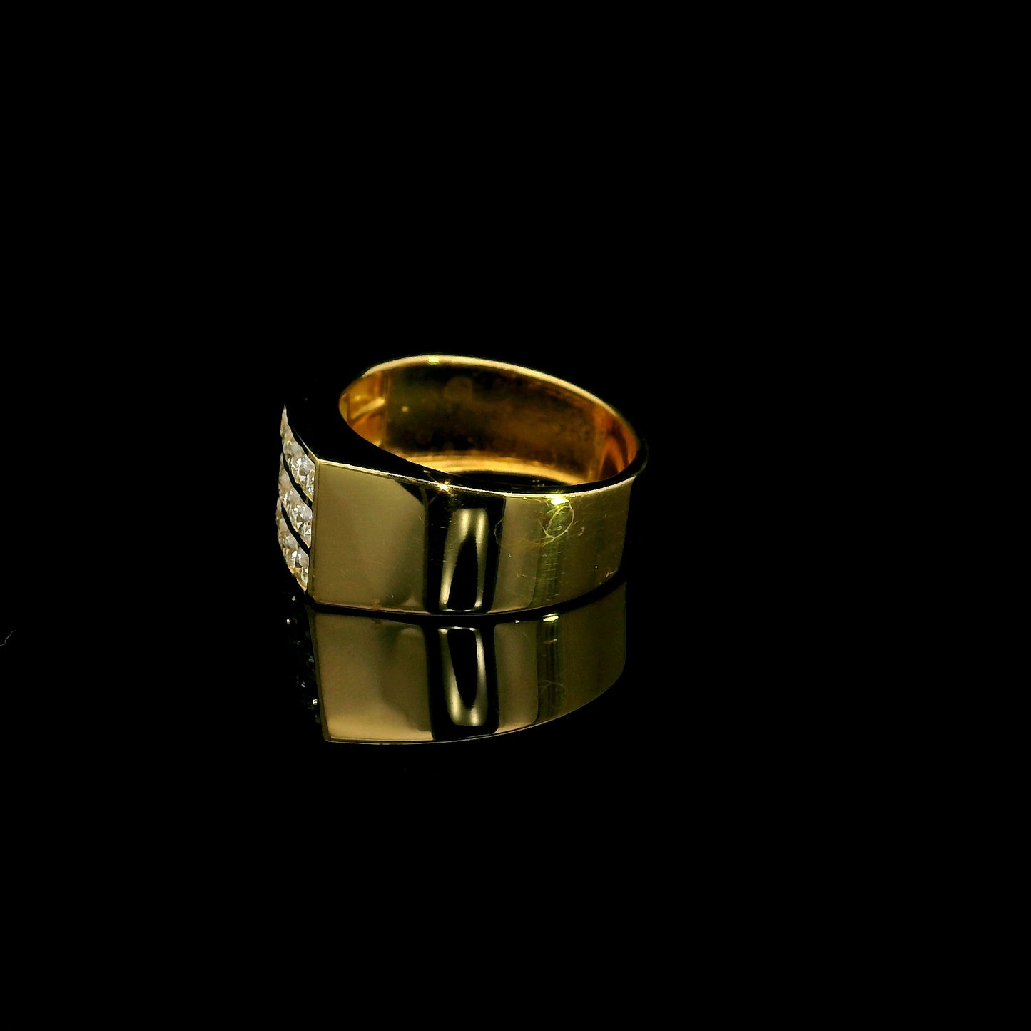 Men’s diamond statement ring in 18K yellow gold featuring three rows of round brilliant diamonds across a wide tapered gold band.