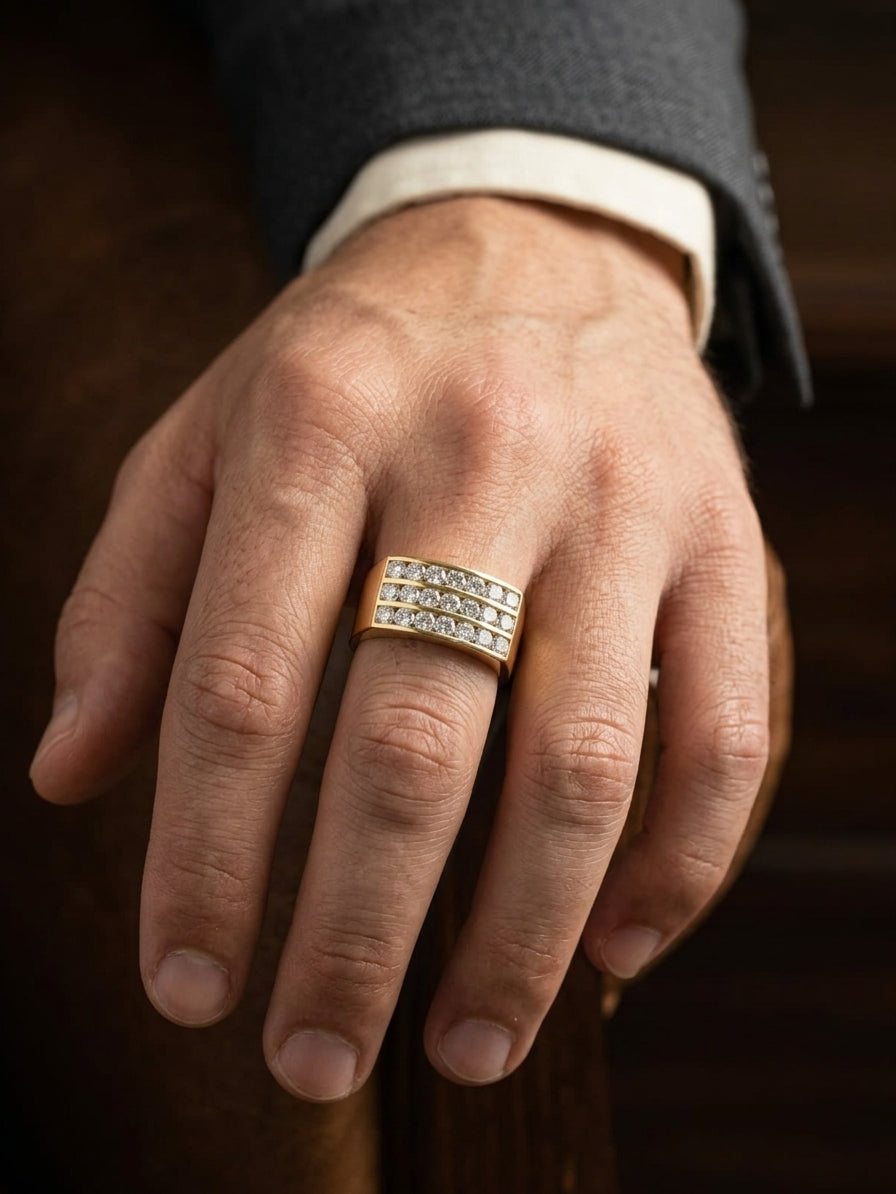 Men’s diamond statement ring in 18K yellow gold featuring three rows of round brilliant diamonds across a wide tapered gold band.