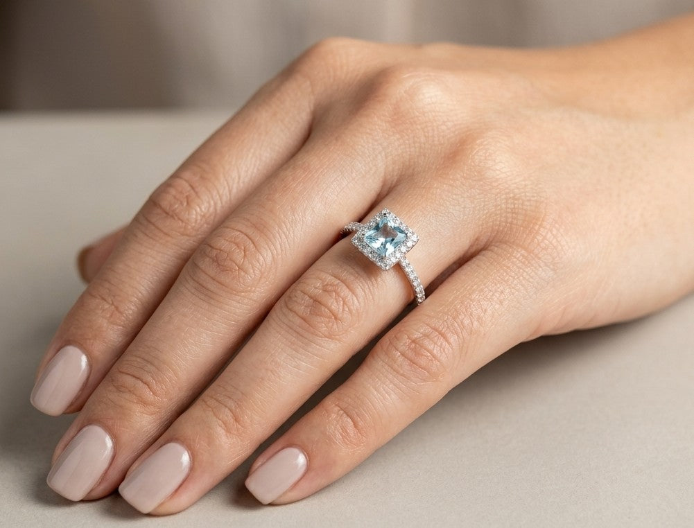 18K white gold aquamarine and diamond halo ring with 0.55 carat square aquamarine and diamond-set band.