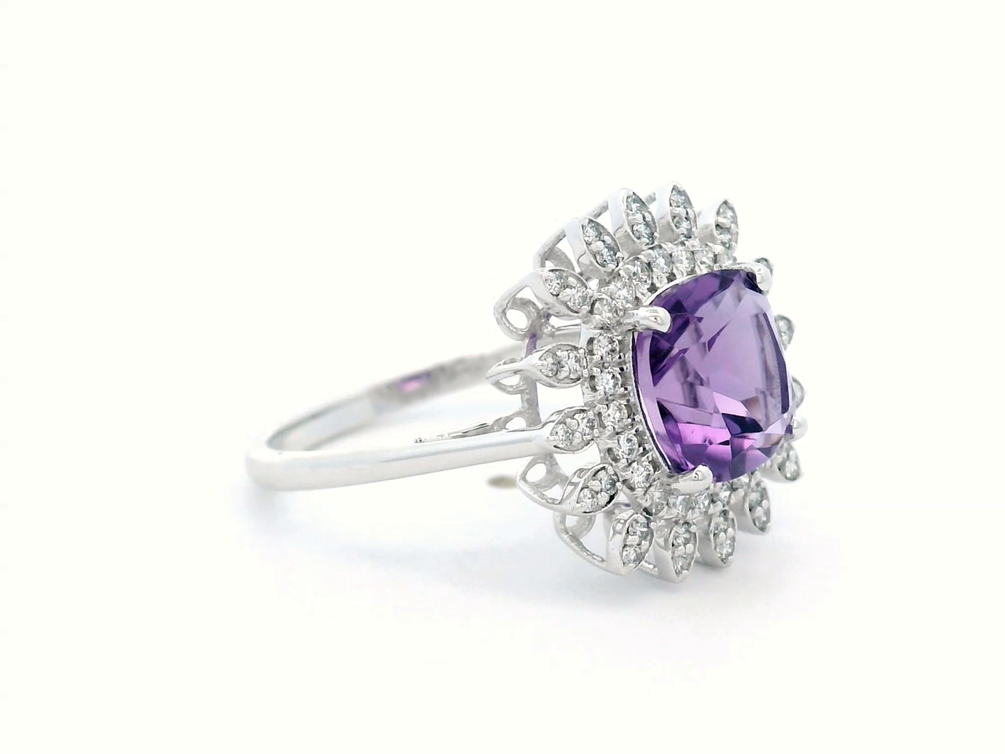 Elegant amethyst and diamond sunburst ring in 18K gold, featuring a 1.30-carat cushion-cut amethyst and 0.17-carat diamonds in a radiant halo design.