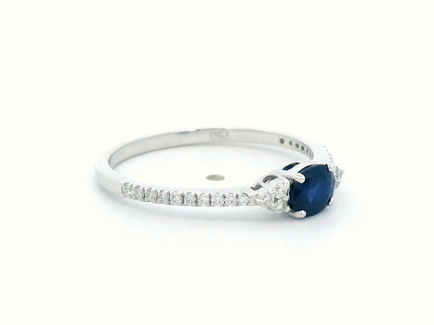 18K white gold sapphire and diamond ring featuring a 0.46-carat oval blue sapphire with 0.15 carats of sparkling diamonds on a delicate band.