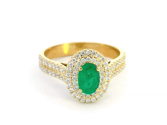 Luxury 18K gold emerald and diamond ring featuring a 0.53-carat oval-cut emerald, encircled by a double halo of 0.54-carat diamonds with a pave-set split shank design – a perfect statement ring for women.