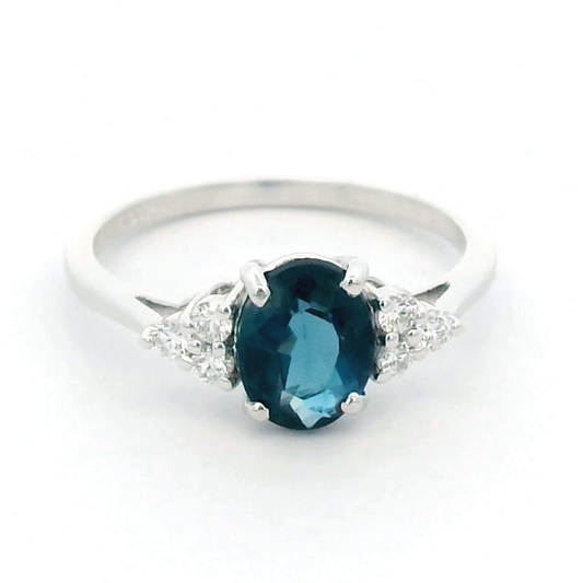 18K gold London Blue Topaz and diamond ring with a 1.30-carat oval-cut gemstone and 0.17 carats of round diamonds in a classic setting. Perfect blue gemstone ring for women.