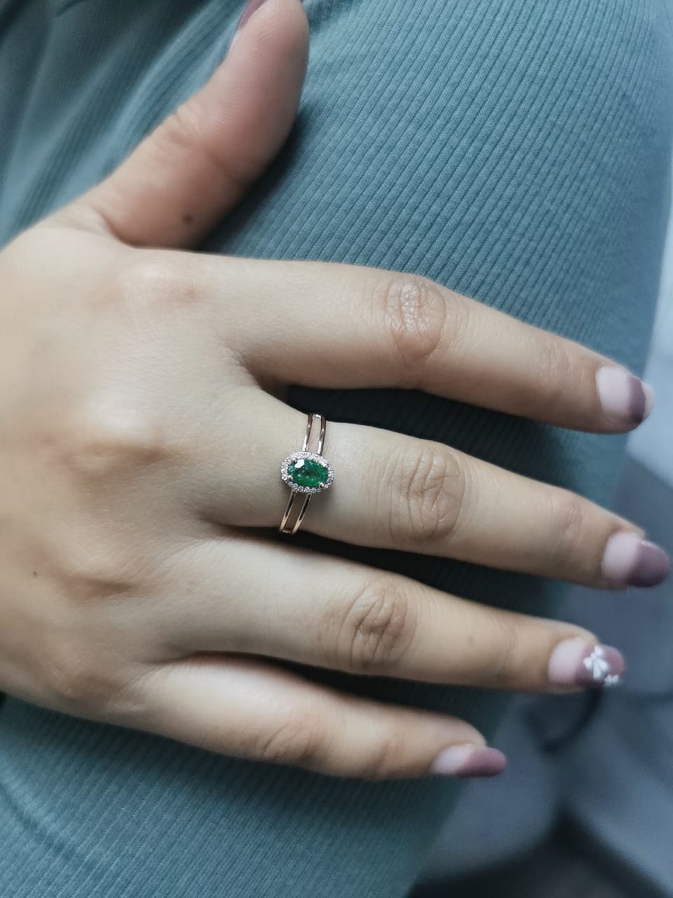 18K rose gold double-band ring featuring a 0.40-carat oval-cut emerald with a 0.05-carat diamond halo – elegant and timeless jewelry.