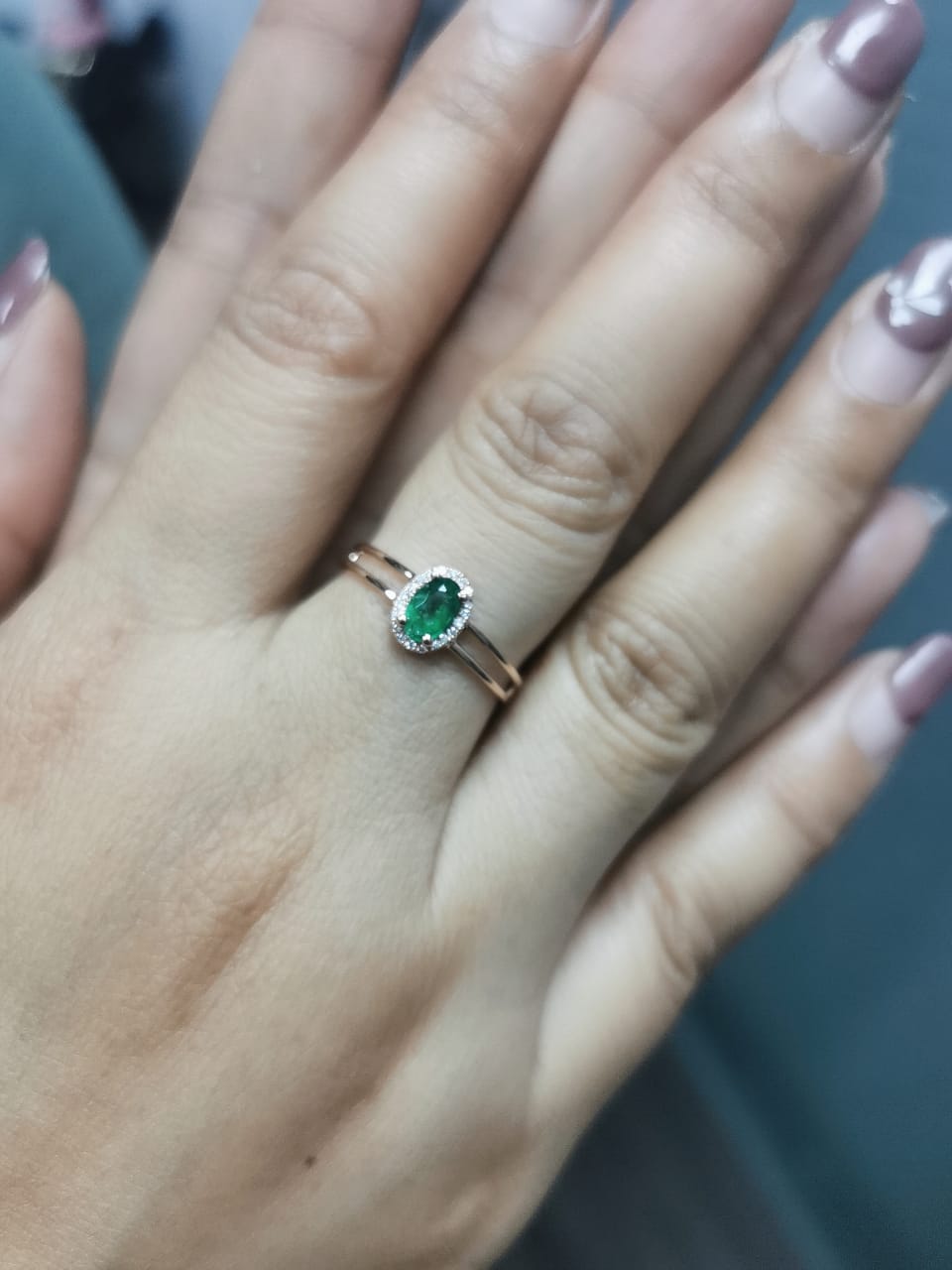 18K rose gold double-band ring featuring a 0.40-carat oval-cut emerald with a 0.05-carat diamond halo – elegant and timeless jewelry.