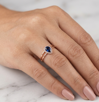 18K Rose Gold Pear Blue Sapphire Halo Ring featuring a 0.51 carat natural pear-shaped blue sapphire surrounded by a delicate diamond halo and a modern double-band design.