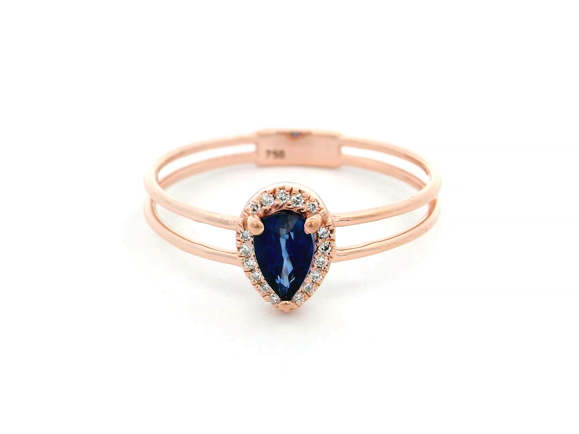 Elegant pear-shaped sapphire and diamond halo ring in 18K gold, featuring a 0.51-carat sapphire and 0.05-carat diamonds in a modern double-band design.