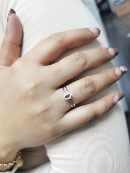 Elegant 18K gold ring featuring a marquise-cut ruby (0.14 carats) encircled by a halo of round-cut diamonds (0.05 carats) with a sleek split band design.