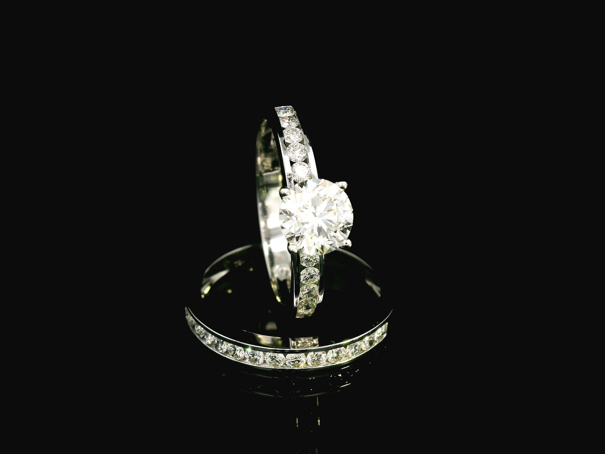 18K white gold bridal set with a 1.00-carat SI2, H-color center diamond, featuring channel-set accent diamonds totaling 0.72 carats on the engagement ring and wedding band