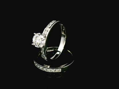 18K white gold bridal set with a 1.00-carat SI2, H-color center diamond, featuring channel-set accent diamonds totaling 0.72 carats on the engagement ring and wedding band