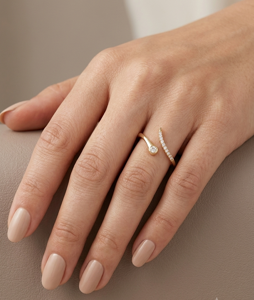 18K yellow gold bypass diamond ring featuring a bezel-set round natural diamond with a pavé diamond open band.
