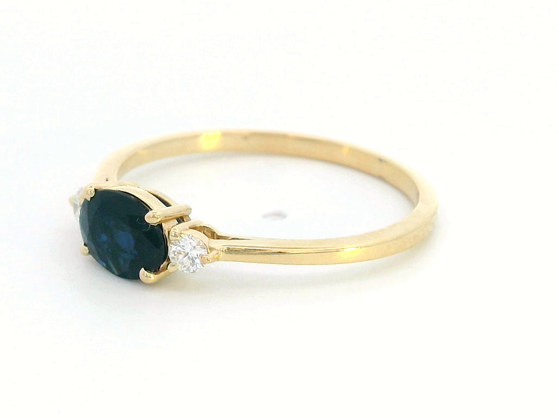 18K gold ring featuring a 0.57 carat oval blue sapphire and 0.09 carat diamonds 