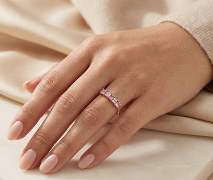 Pink sapphire and diamond ring in 18K rose gold with three princess cut pink sapphires and round diamond cluster accents
