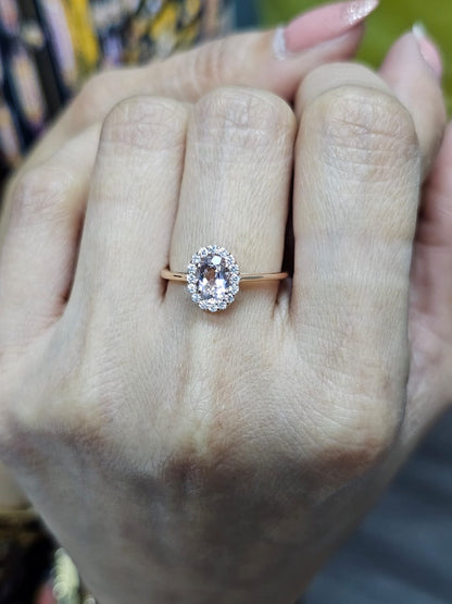 18K rose gold ring featuring a 0.64-carat oval peachy pink morganite, surrounded by a sparkling diamond halo with a total weight of 0.17 carats, showcasing an elegant and polished design.