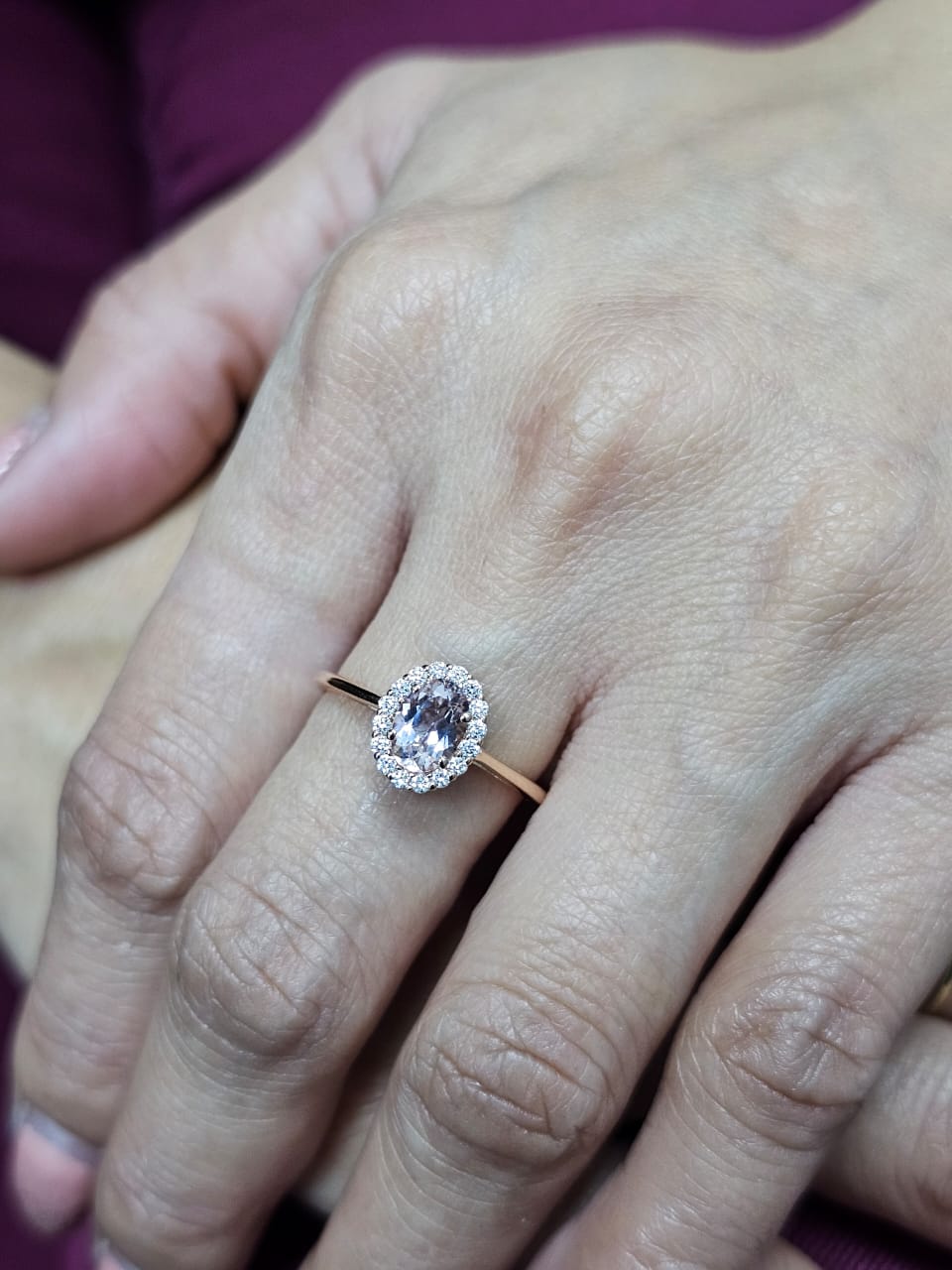 18K rose gold ring featuring a 0.64-carat oval peachy pink morganite, surrounded by a sparkling diamond halo with a total weight of 0.17 carats, showcasing an elegant and polished design.