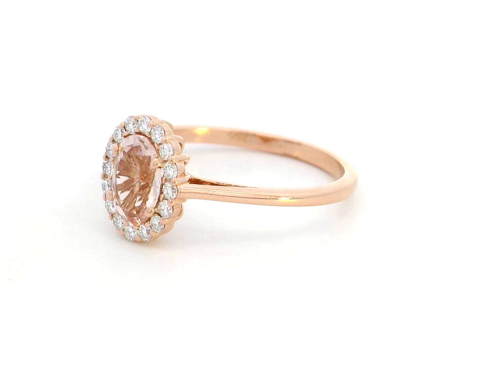 18K rose gold ring featuring a 0.64-carat oval peachy pink morganite, surrounded by a sparkling diamond halo with a total weight of 0.17 carats, showcasing an elegant and polished design.