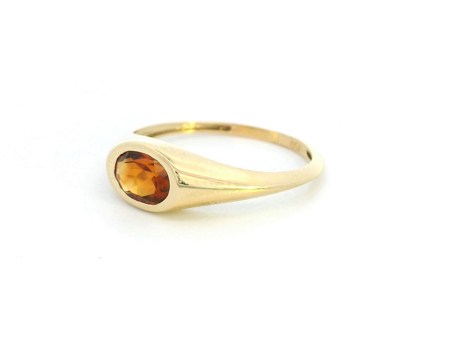 18K yellow gold ring with a 0.66-carat oval-shaped citrine in a bezel setting.