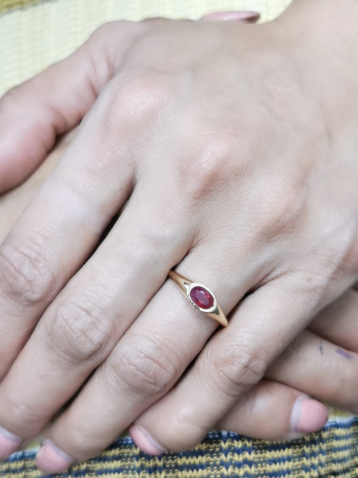 18K yellow gold ring with a 0.75-carat oval-shaped ruby in a classic bezel setting.