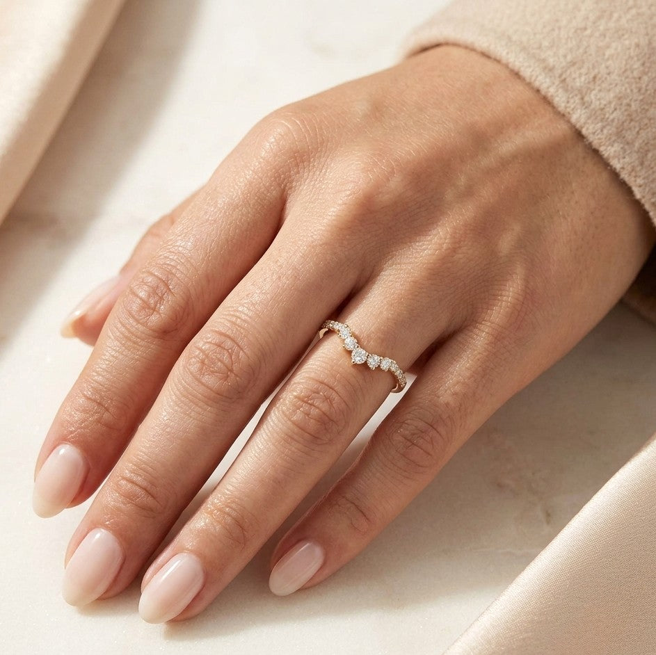 Curved diamond wedding band in 18K yellow gold with graduated round diamonds, designed for stacking or pairing with an engagement ring