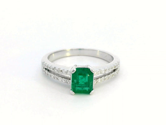 18K white gold emerald ring featuring a 0.78-carat emerald-cut green emerald with 0.25-carat diamond accents on a split band.