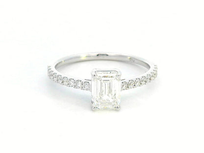 A 1.20-carat emerald-cut diamond ring set in 18K gold, featuring a diamond-studded band with 0.24 carats of round diamonds. Elegant engagement or statement jewelry.