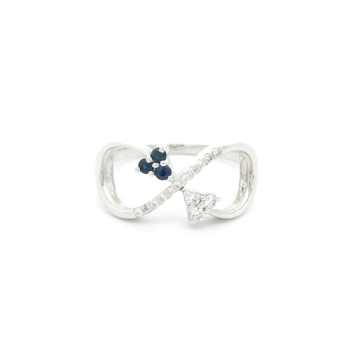 Blue sapphire and diamond infinity ring in 18K white gold with three round blue sapphires and diamond detailing.