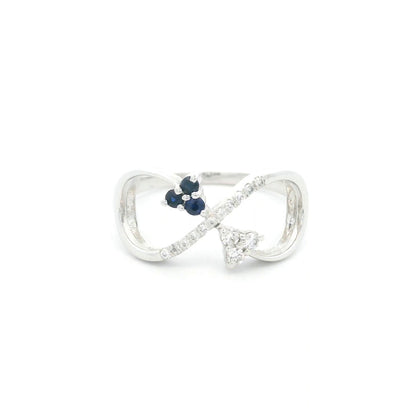 Blue sapphire and diamond infinity ring in 18K white gold with three round blue sapphires and diamond detailing.