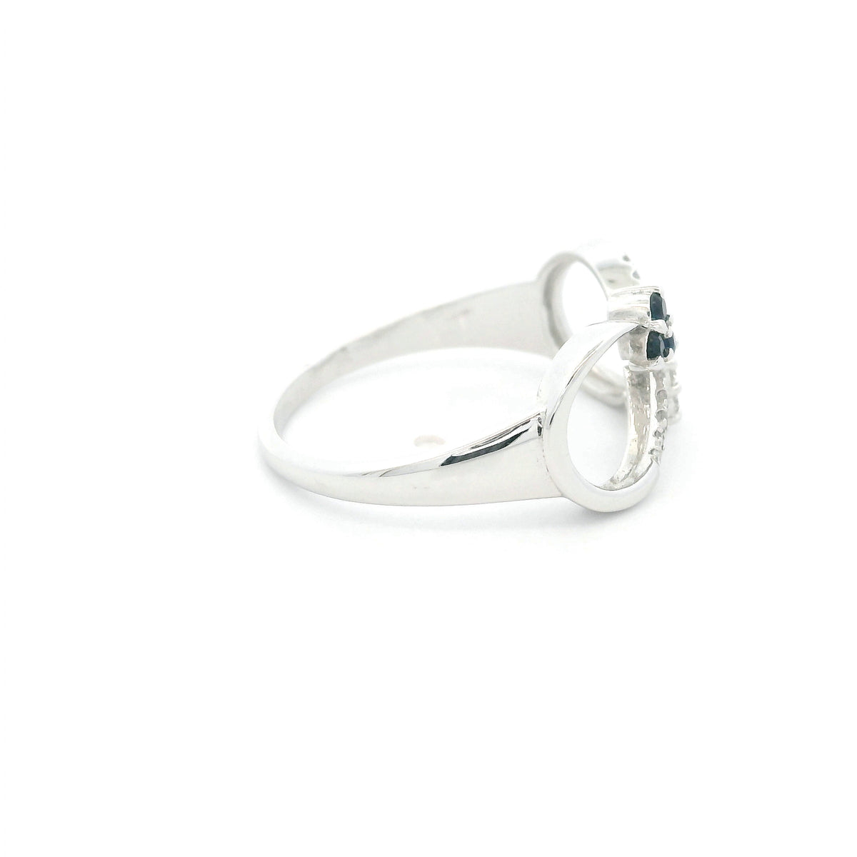 Blue sapphire and diamond infinity ring in 18K white gold with three round blue sapphires and diamond detailing.