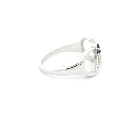 Blue sapphire and diamond infinity ring in 18K white gold with three round blue sapphires and diamond detailing.