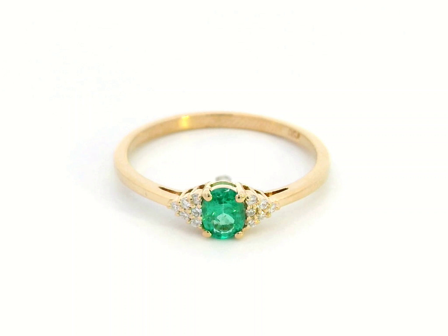 Petite 18K gold ring featuring a 0.30-carat emerald center stone, accented by 0.06-carat diamonds. Perfect for stacking or wearing alone.