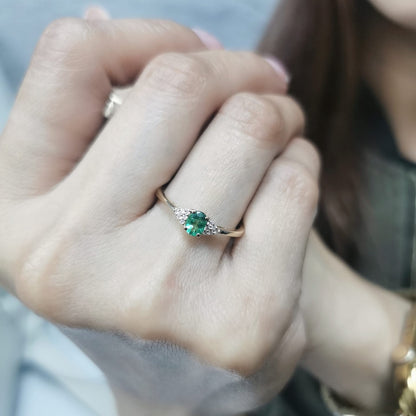 Petite 18K gold ring featuring a 0.30-carat emerald center stone, accented by 0.06-carat diamonds. Perfect for stacking or wearing alone.