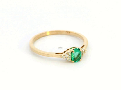 Petite 18K gold ring featuring a 0.30-carat emerald center stone, accented by 0.06-carat diamonds. Perfect for stacking or wearing alone.