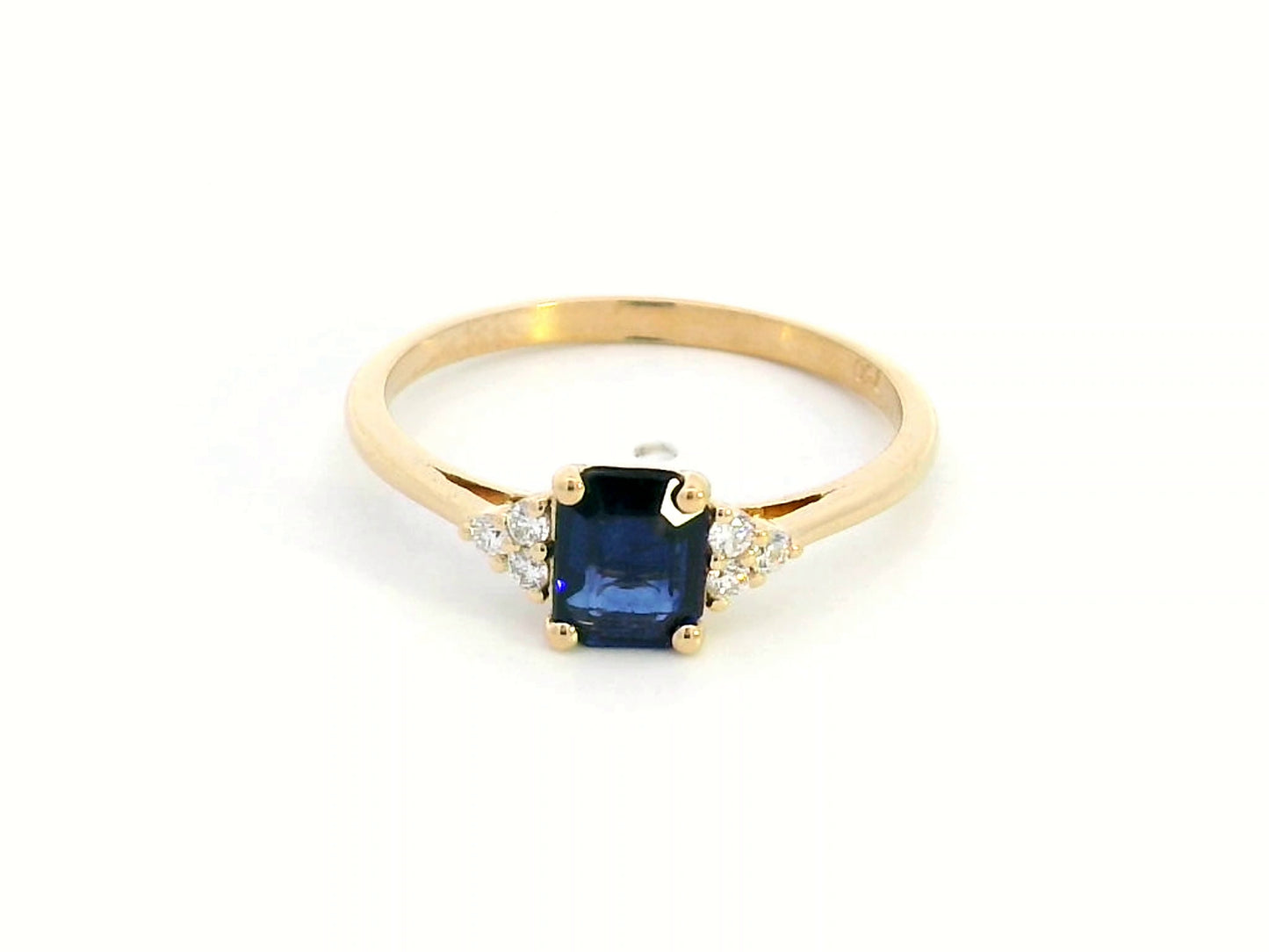 Petite 18K gold ring featuring a 0.68-carat emerald-cut blue sapphire, accented by 0.08-carat diamonds. Perfect for stacking or wearing alone.