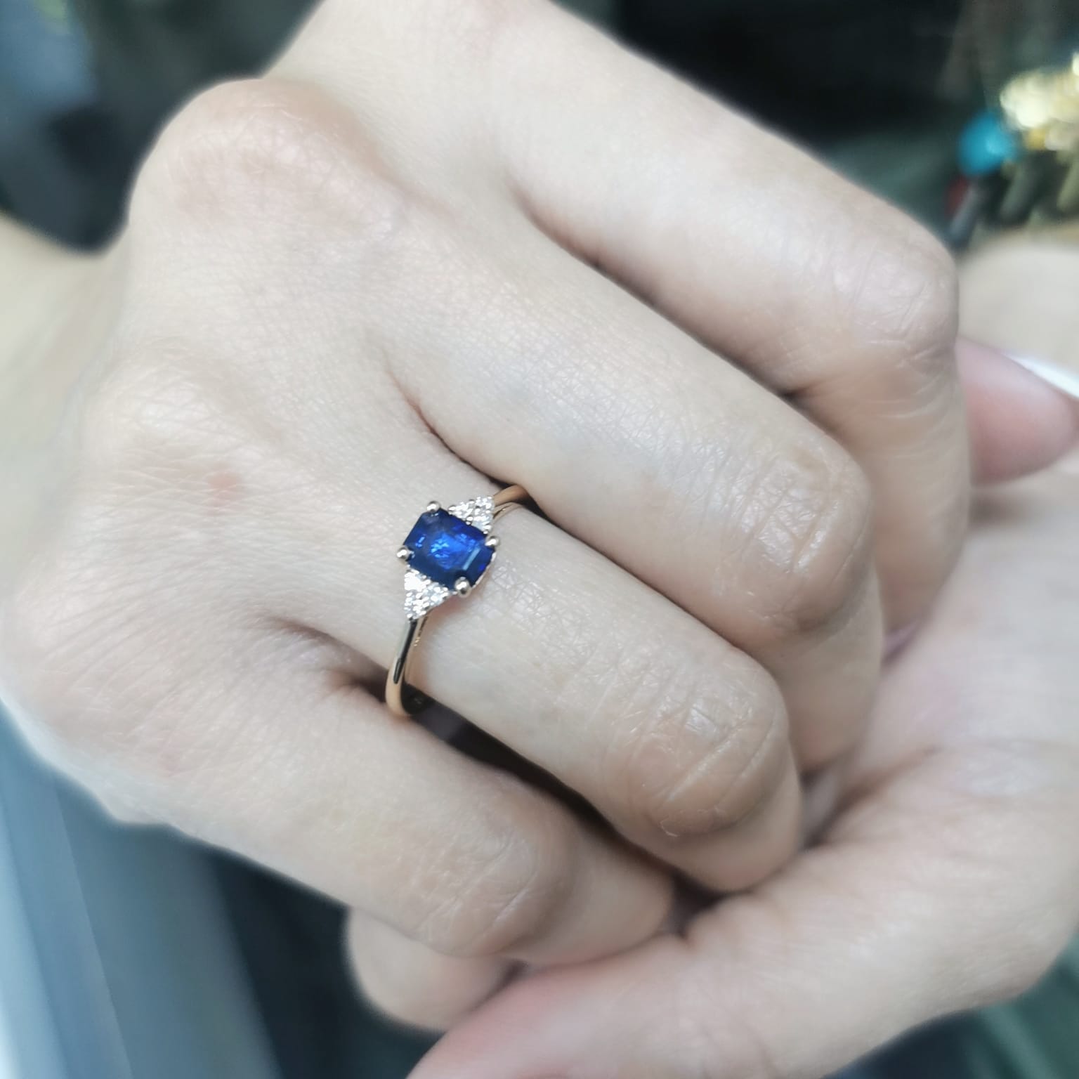 Petite 18K gold ring featuring a 0.68-carat emerald-cut blue sapphire, accented by 0.08-carat diamonds. Perfect for stacking or wearing alone.