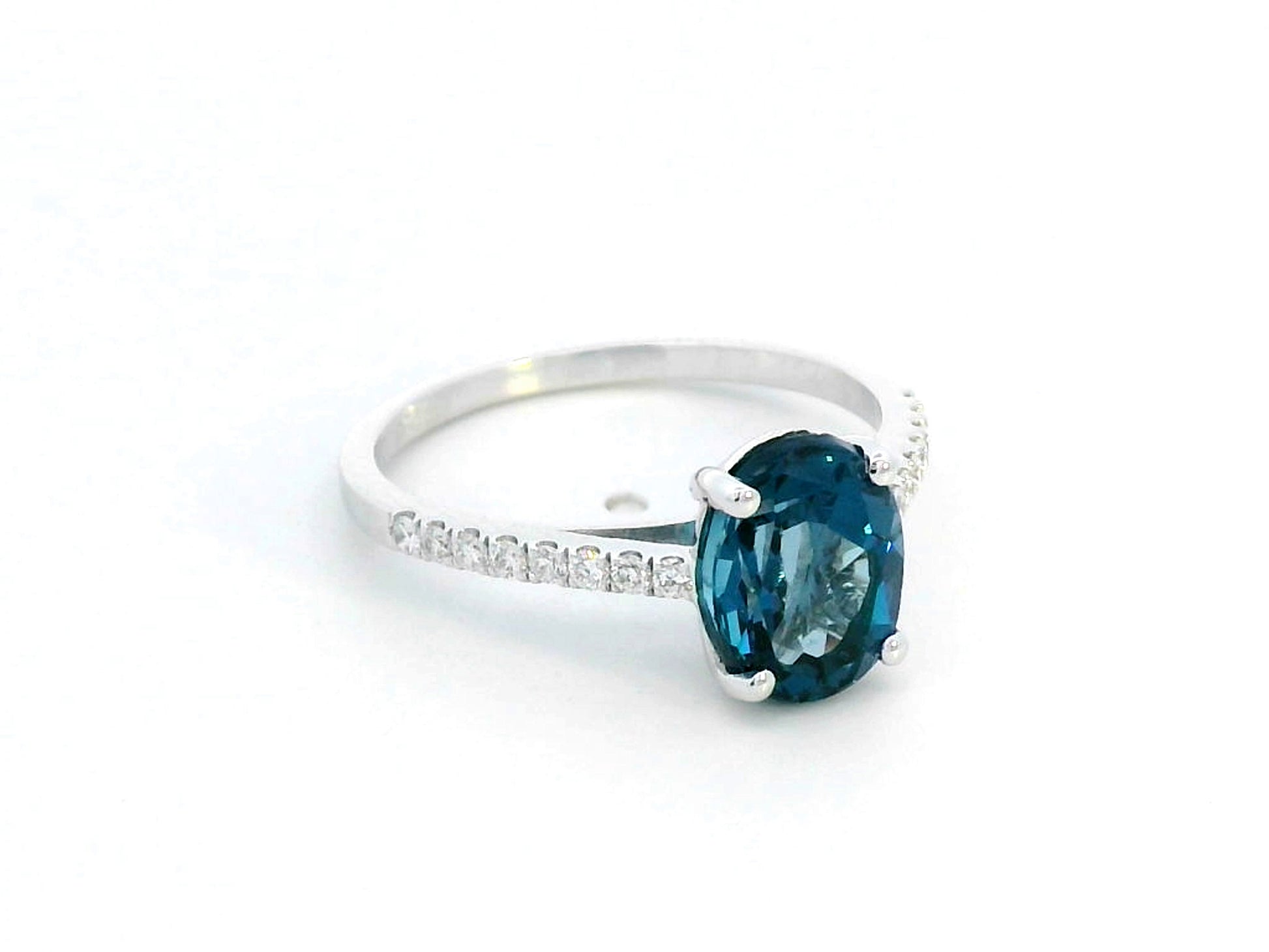 Elegant 18K white gold ring with a 2.48-carat oval London blue topaz center stone and a 0.16-carat diamond-accented band.