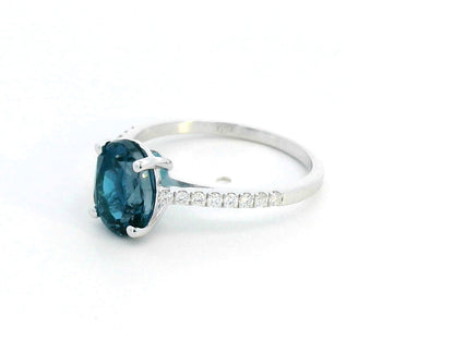 Elegant 18K white gold ring with a 2.48-carat oval London blue topaz center stone and a 0.16-carat diamond-accented band.