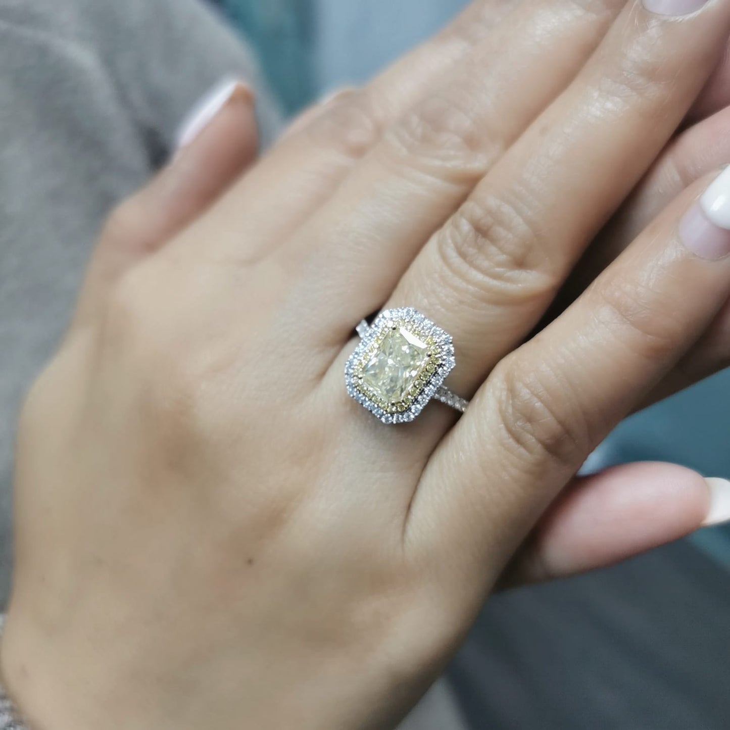 GIA-certified 2.02-carat fancy yellow radiant-cut diamond engagement ring with a double halo of yellow and white diamonds, accent diamonds set on an 18K gold band.