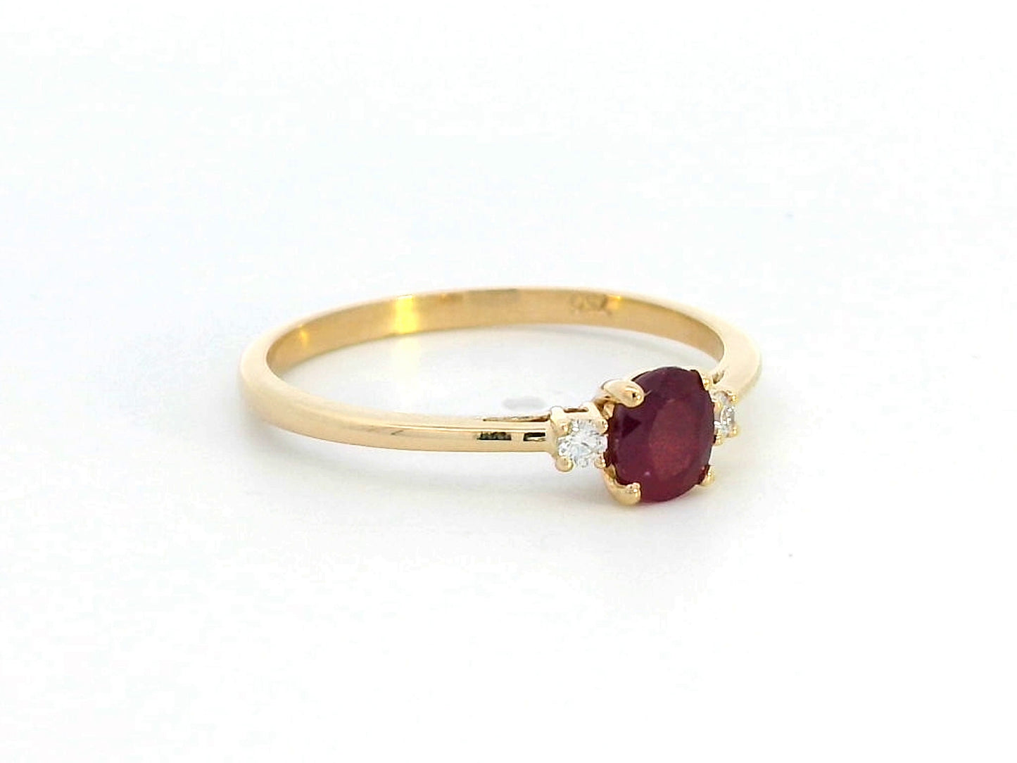 18K gold ruby and diamond ring featuring a 0.47-carat oval ruby with two round diamonds (0.05ct) in a classic minimalist setting – fine jewelry for engagement, anniversary, or gifting.