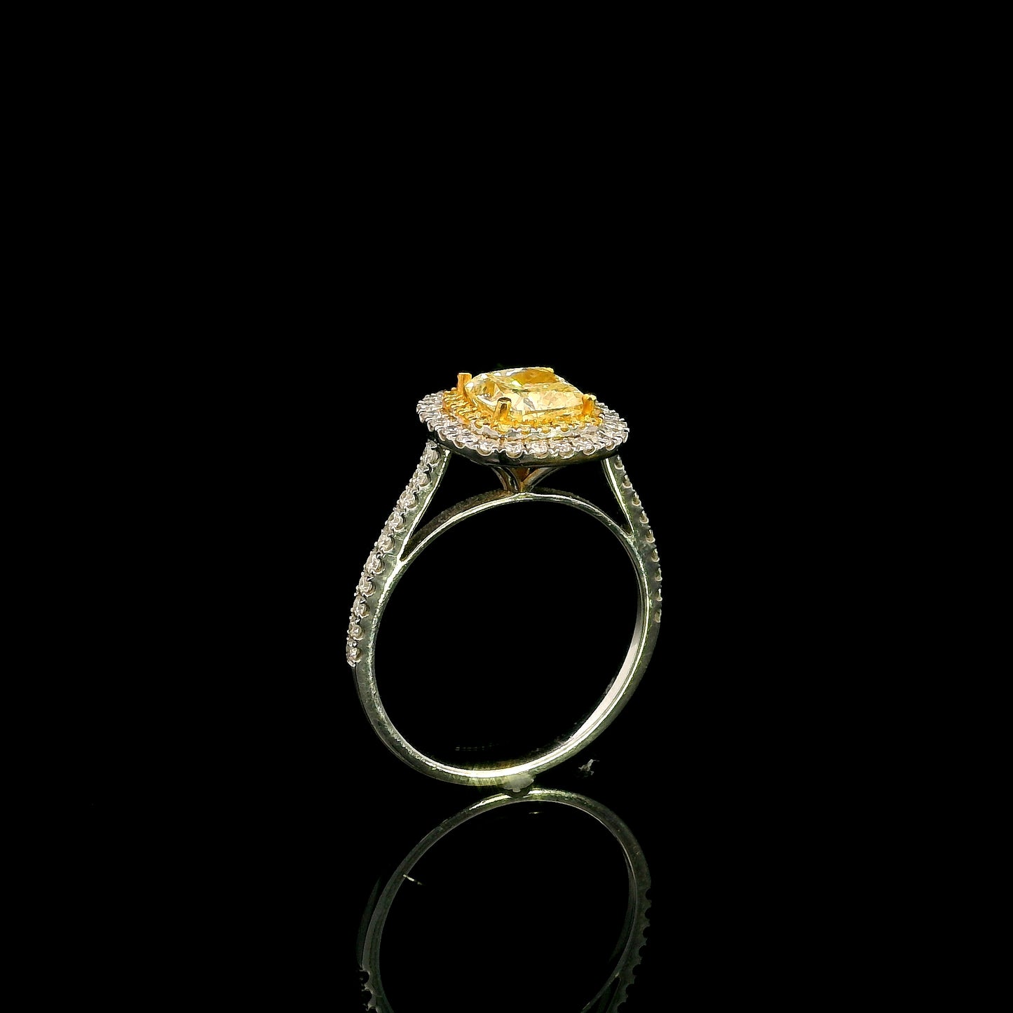 18K white gold engagement ring featuring a 1.50 carat GIA certified natural Fancy Yellow cushion cut diamond surrounded by a yellow diamond inner halo, white diamond outer halo, and diamond pavé band.
