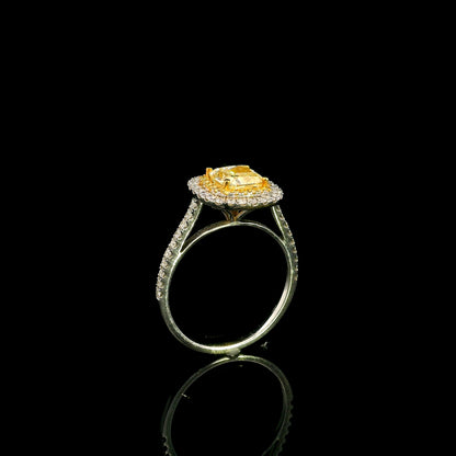 18K white gold engagement ring featuring a 1.50 carat GIA certified natural Fancy Yellow cushion cut diamond surrounded by a yellow diamond inner halo, white diamond outer halo, and diamond pavé band.