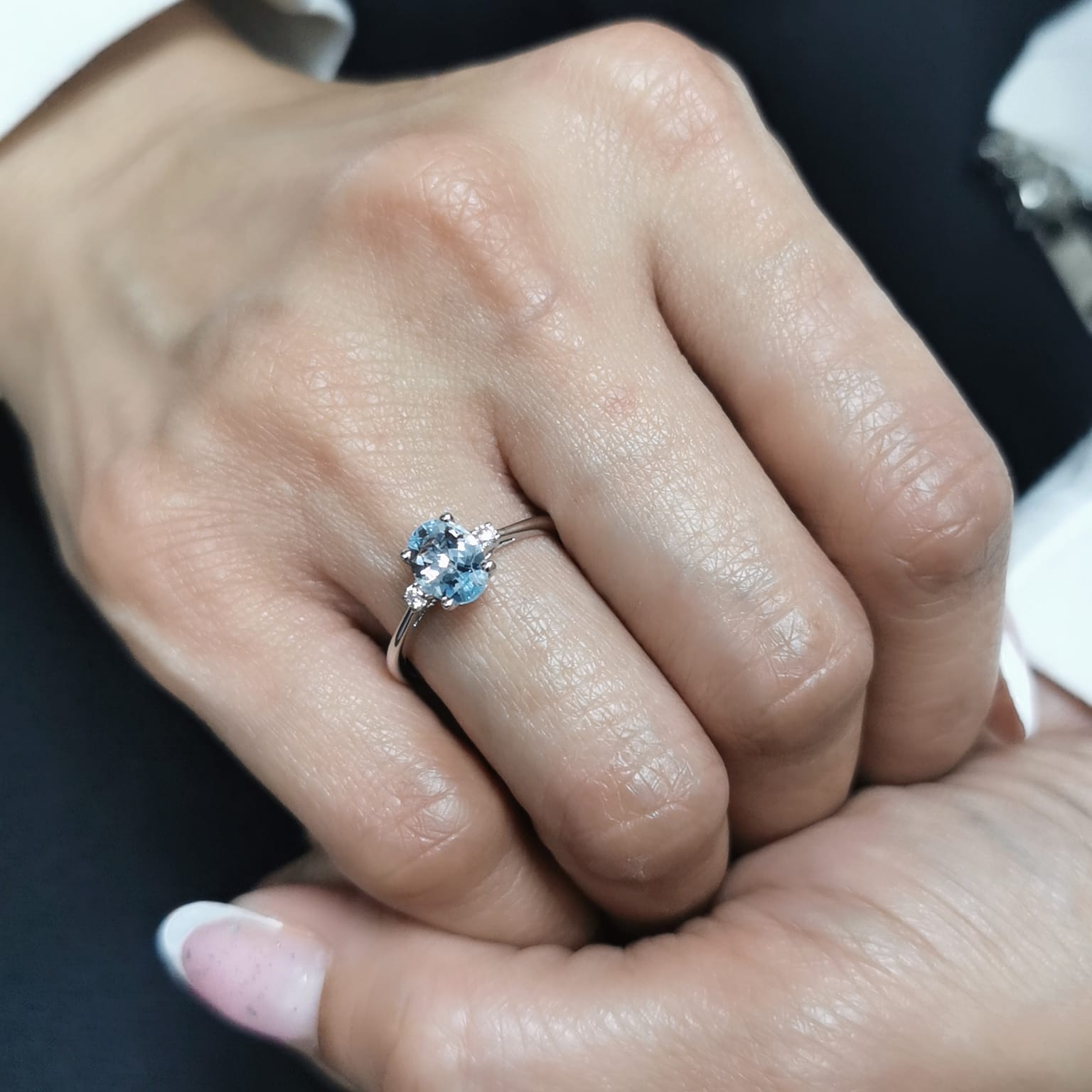 Oval Aquamarine and diamond ring in 18K gold, featuring a 0.93ct blue gemstone flanked by round-cut diamonds. 