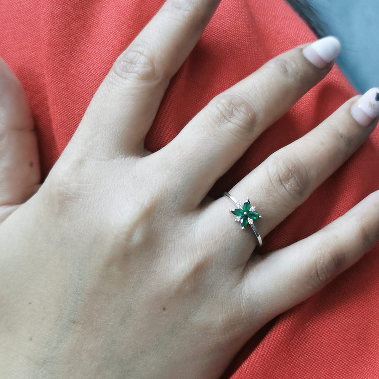 18K gold floral ring featuring 0.31 CT natural emeralds and 0.05 CT diamonds, designed in a delicate flower shape.