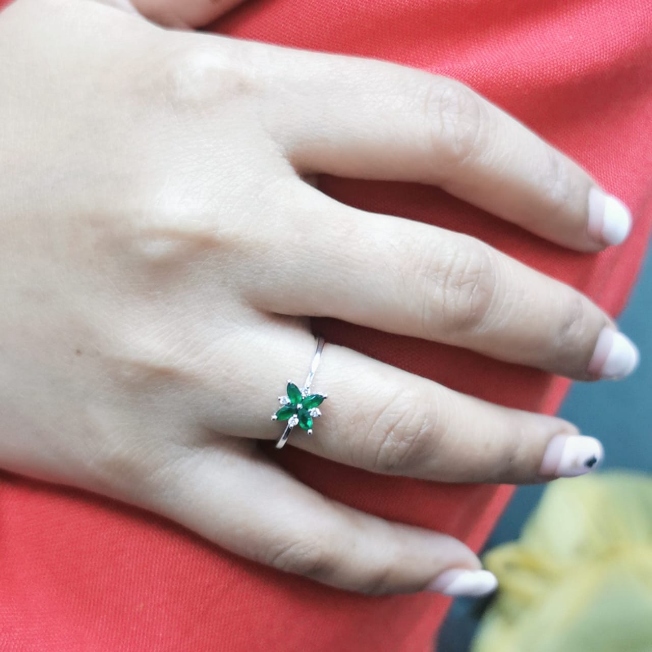 18K gold floral ring featuring 0.31 CT natural emeralds and 0.05 CT diamonds, designed in a delicate flower shape.