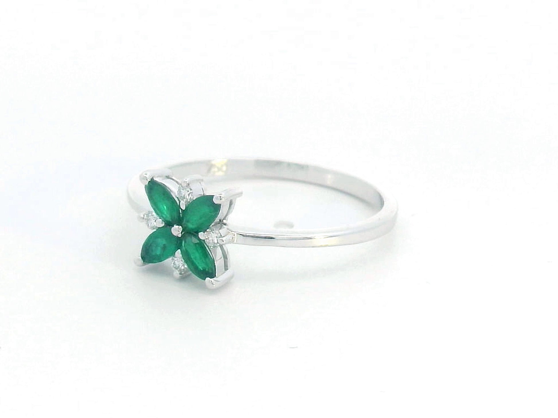 18K gold floral ring featuring 0.31 CT natural emeralds and 0.05 CT diamonds, designed in a delicate flower shape.